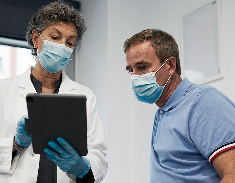 Imagem de profissional da saúde e paciente olhando tablet