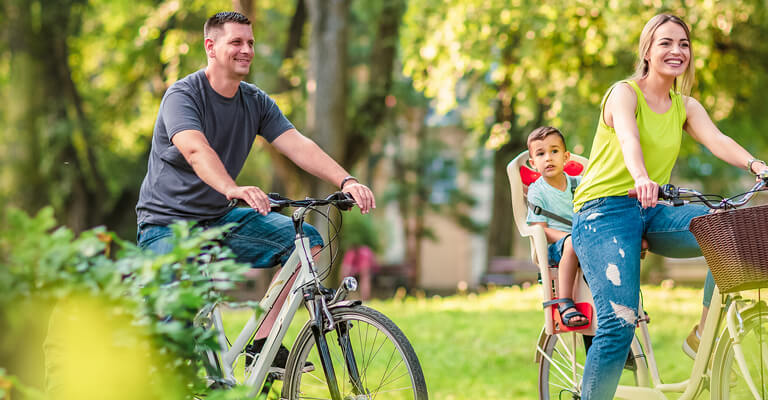 Família feliz ao ar livre andando de bicicleta